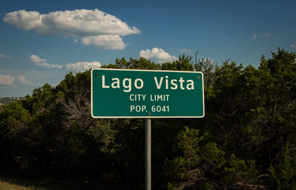 A close up of a street sign with trees in the background

Description automatically generated